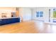 Bright open-concept living room with wood tile floors and a modern kitchen featuring white cabinets at 14073 Naylor Ave, Port Charlotte, FL 33981