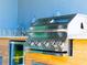 Stainless steel outdoor grill set in modern outdoor kitchen with wood-look tile at 14073 Naylor Ave, Port Charlotte, FL 33981