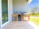 Outdoor kitchen with stainless grill, mini fridge, sink and tile flooring at 14073 Naylor Ave, Port Charlotte, FL 33981
