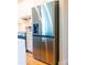 New stainless steel refrigerator in a modern kitchen with white cabinets and gold hardware at 14073 Naylor Ave, Port Charlotte, FL 33981