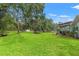 Large grassy backyard with mature trees and a covered patio perfect for outdoor entertaining at 15364 Mount Sparrow Rd, Weeki Wachee, FL 34614
