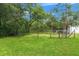 Large, fenced backyard features lush green grass and mature trees at 15364 Mount Sparrow Rd, Weeki Wachee, FL 34614