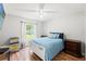 Cozy bedroom featuring wood floors, a ceiling fan, and a window overlooking the backyard at 15364 Mount Sparrow Rd, Weeki Wachee, FL 34614
