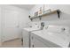 Laundry room with white washer and dryer, decorated shelf, and tiled floors at 15364 Mount Sparrow Rd, Weeki Wachee, FL 34614