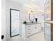 Modern bathroom featuring a white vanity with granite countertop and black fixtures at 2556 Arborwood Dr, Valrico, FL 33596