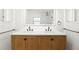 Bathroom featuring double sinks, wood cabinets, quartz countertops, modern fixtures, and a large mirror at 2556 Arborwood Dr, Valrico, FL 33596
