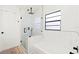 Bathroom boasting a glass-enclosed shower, a tiled bathtub, and a bright window at 2556 Arborwood Dr, Valrico, FL 33596