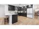 Modern kitchen features sleek, dark cabinetry, stainless steel appliances, quartz countertops and a stylish breakfast bar at 2556 Arborwood Dr, Valrico, FL 33596