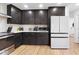 Well-lit kitchen featuring stainless steel appliances, dark wood cabinets, white countertops, and wood-look flooring at 2556 Arborwood Dr, Valrico, FL 33596