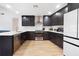 This kitchen offers a modern style with stainless steel appliances, dark cabinets, quartz countertops and wood flooring at 2556 Arborwood Dr, Valrico, FL 33596