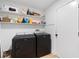 Functional laundry room offers modern washer and dryer, plus ample storage shelving at 2556 Arborwood Dr, Valrico, FL 33596