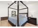 Comfortable main bedroom showcasing a four-poster bed, neutral color scheme, and wood-look flooring at 2556 Arborwood Dr, Valrico, FL 33596