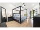 Spacious main bedroom featuring a four-poster bed, soft lighting, neutral tones, and access to an outdoor space at 2556 Arborwood Dr, Valrico, FL 33596