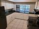 Bright kitchen featuring white cabinets, black countertops and appliances at 8035 Robin Rd, Seminole, FL 33777