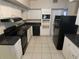 Traditional kitchen featuring white cabinetry and black appliances at 8035 Robin Rd, Seminole, FL 33777