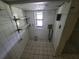 This laundry room features tiled walls and floors, shelving and a window for natural light at 8035 Robin Rd, Seminole, FL 33777