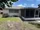 Home exterior with a screened in patio, and a grassy yard at 9825 Sandstone Ln, Port Richey, FL 34668