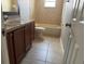 Bathroom featuring tile floors, a vanity with cabinets, and a tub with tile surround at 9825 Sandstone Ln, Port Richey, FL 34668