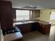 The kitchen features wood cabinets, a window above the sink, and modern appliances at 9825 Sandstone Ln, Port Richey, FL 34668