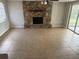 Spacious living room featuring a stone fireplace, neutral tile, and sliding glass doors to the patio at 9825 Sandstone Ln, Port Richey, FL 34668