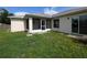 Exterior view of the home's screened patio and grassy backyard at 1140 Belmar Ave, Port Charlotte, FL 33948
