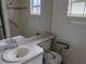 Bathroom features a sink, toilet with accessibility handle, and a shower with grab bars for safety at 1140 Belmar Ave, Port Charlotte, FL 33948