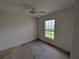 A bedroom with view of the yard through a window and ceiling fan at 1140 Belmar Ave, Port Charlotte, FL 33948