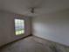 A bedroom with view of the yard through a window and ceiling fan at 1140 Belmar Ave, Port Charlotte, FL 33948