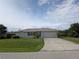 Well-maintained one-story home with a manicured lawn, attached garage, and a concrete driveway at 1140 Belmar Ave, Port Charlotte, FL 33948