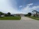Charming single-Gathering home with a spacious front yard, concrete driveway, and attached garage on a sunny day at 1140 Belmar Ave, Port Charlotte, FL 33948