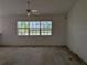 Bright living room featuring large windows, a ceiling fan, and light-colored walls at 1140 Belmar Ave, Port Charlotte, FL 33948