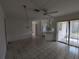 Open living room with tile floors, ceiling fan and sliding glass door to screened patio at 1140 Belmar Ave, Port Charlotte, FL 33948
