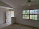 Living room with an open doorway and a large window view to the front of the house at 1140 Belmar Ave, Port Charlotte, FL 33948