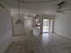 Open living area with tile floors, ceiling fan, and kitchen access at 1140 Belmar Ave, Port Charlotte, FL 33948