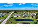 A view of several homes with well-manicured lawns near a serene lake and lush green spaces at 142 Broadmoor Ln, Rotonda West, FL 33947