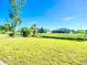 Scenic backyard with lush greenery, a serene canal, and charming home in the distance at 142 Broadmoor Ln, Rotonda West, FL 33947