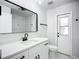 A clean bathroom featuring white cabinetry, modern fixtures, and a convenient door to the outside at 142 Broadmoor Ln, Rotonda West, FL 33947