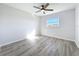 Sunlit bedroom with wood-look flooring, a ceiling fan, and large window at 142 Broadmoor Ln, Rotonda West, FL 33947
