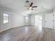 This sunlit bedroom boasts a ceiling fan and stylish wood-look flooring, creating a modern and comfortable ambiance at 142 Broadmoor Ln, Rotonda West, FL 33947