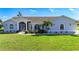 Charming single-story home with lush lawn, manicured shrubs, and welcoming screened entryway, and decorative windows at 142 Broadmoor Ln, Rotonda West, FL 33947