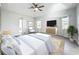 Bright main bedroom with tray ceiling, ceiling fan, wood floors, and a picturesque view from the windows at 142 Broadmoor Ln, Rotonda West, FL 33947