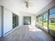 Enclosed sunroom with tile flooring, ceiling fan, and sliding glass doors at 142 Broadmoor Ln, Rotonda West, FL 33947