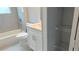 Bright bathroom with a tub, shower, white vanity, and a convenient storage closet with wire shelving at 1495 Craleigh St, North Port, FL 34288