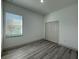 Cozy bedroom with a window, closet, and gray wood floors at 1495 Craleigh St, North Port, FL 34288