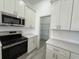 Stylish kitchen featuring stainless steel appliances, a pantry, and modern white cabinetry at 1495 Craleigh St, North Port, FL 34288