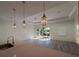 Bright living room with modern light fixtures, gray flooring, and sliding glass doors at 1495 Craleigh St, North Port, FL 34288