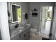Bathroom vanity with a gray countertop, modern illuminated mirror, and view of the screened patio at 1884 Coconut Palm Cir, North Port, FL 34288