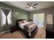 Comfortable bedroom with green accent wall, ceiling fan and sliding glass doors to outdoor patio at 1884 Coconut Palm Cir, North Port, FL 34288