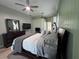 Primary bedroom features green accent wall, ceiling fan, dresser, and a TV at 1884 Coconut Palm Cir, North Port, FL 34288