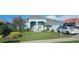 Beautiful one-story home with a blue exterior, landscaped front yard, and a two-car garage at 1884 Coconut Palm Cir, North Port, FL 34288